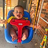 Ronan joined the competition — help win amazing prizes! baby, child, swing, blue, red, smiling, happy, outdoor, toy, giraffe, colorful, arms, feet, sunlight, porch, brick_wall, rope, playful, bubbles, infant