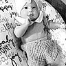baby, infant, child, bow, headwear, pillow, text, words, love, joy, smile, clothing, cute, indoors, monochrome, black_and_white, person, portrait, sitting, floor