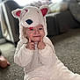 toddler, child, costume, animal_costume, white, fluffy, indoors, carpet, smiling, cute, playful, hood, ears, nose, face, person, sitting, living_room, blurred_background, happy