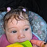 baby, child, face, hair, hair_ties, teether, hand, ring, clothing, seat, pattern, floral, pink, yellow, skin, closeup, indoor, cute, infant, portrait
