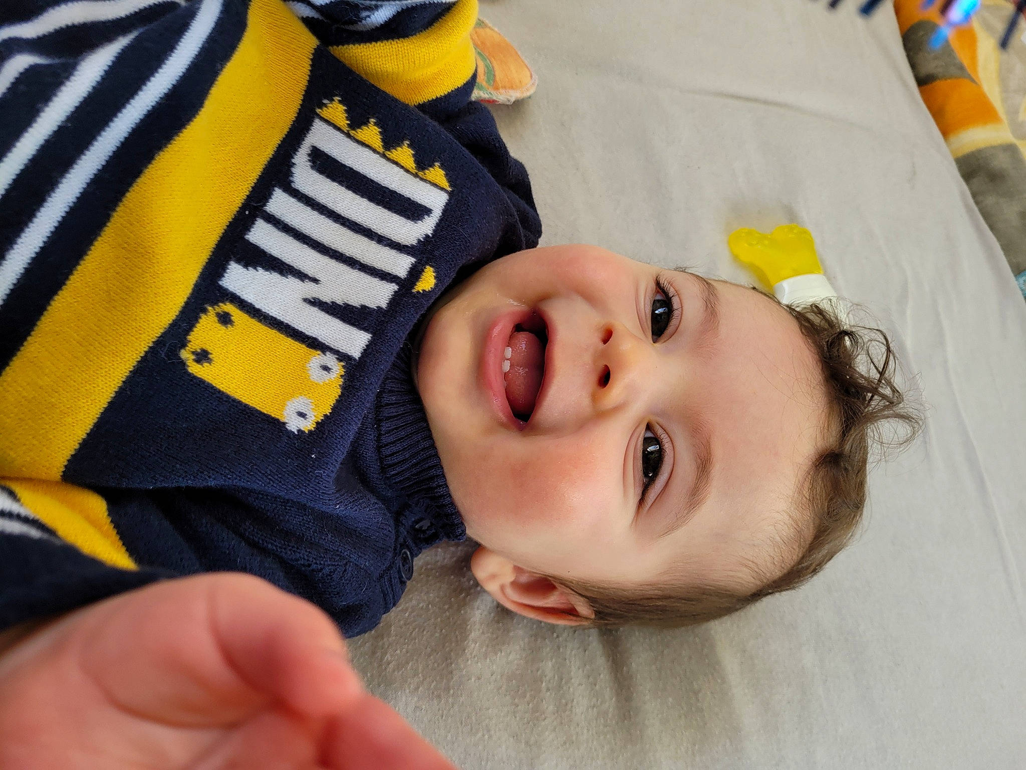 Tilio a rejoint le concours — aidez-le/la à gagner de superbes lots ! baby, baby_laughing, baby_products, baby_toddler_clothing, cheek, child, comfort, eyelash, finger, gesture, happy, nail, nose, person, portrait_photography, room, sleeve, smile, thumb, toddler