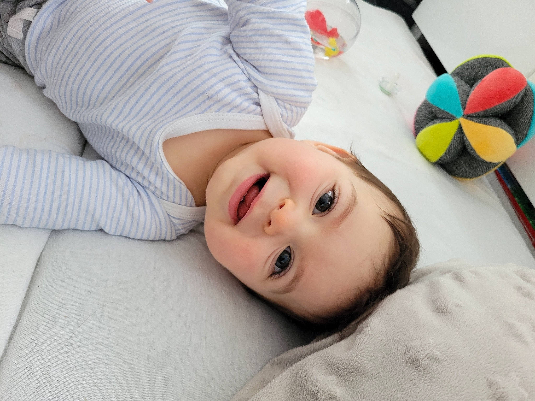 Tilio a rejoint le concours — aidez-le/la à gagner de superbes lots ! baby_toys, child, comfort, eyelash, fashion_accessory, happy, joy, linens, lip, neck, nose, person, portrait_photography, room, skin, sleeve, smile, stuffed_toy, textile, toddler