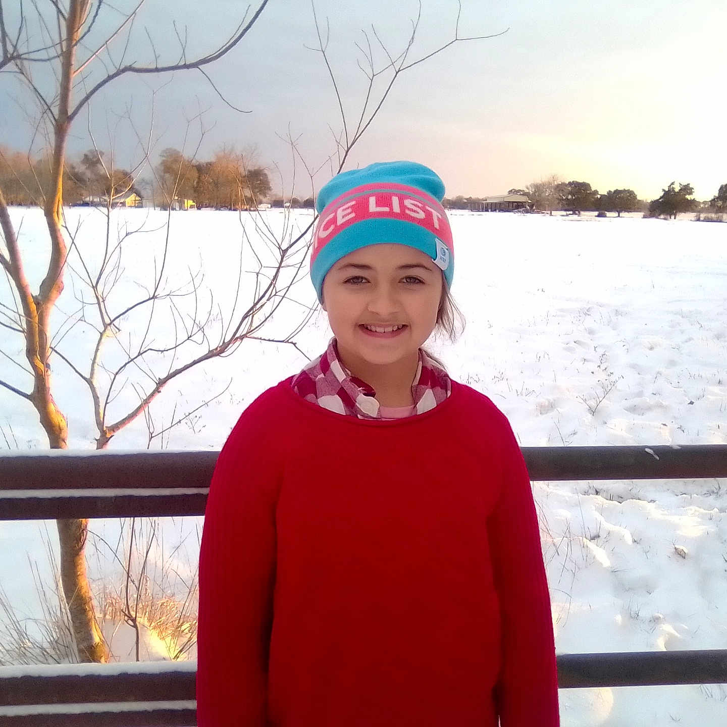 Layla is registered to the contest to win money with this photo: beanie, cap, child, clothing, face, female, girl, glove, happy, hat, head, knitwear, nature, outdoors, person, photography, plant, portrait, sweater, tree