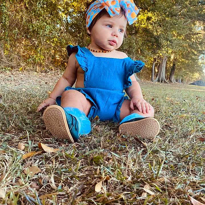 Mila Raine joined the competition — help win amazing prizes! toddler, child, blue_clothing, headband, bow, grass, outdoor, nature, trees, sunlight, portrait, sitting, baby, grass_field, daylight, shoes, cute, young_child, fall_leaves, casual