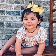 Mila Raine joined the competition — help win amazing prizes! toddler, child, yellow_bow, bench, brick_wall, smiling, cute, outdoor, portrait, sitting, wooden_bench, happy, clothing, person, baby, face, hair_bow, cute_expression, casual, daylight