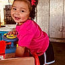 Mila Raine joined the competition — help win amazing prizes! toddler, child, smiling, pink_shirt, hair_bows, toy_car, indoor, play, happy, cute, shorts, person, portrait, curly_hair, bright_colors, wooden_background, sunlight, playful, earrings, casual_clothing