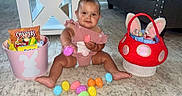 Remi joined the competition — help win amazing prizes! baby, bunny_ears, candy, carpet, child, colorful, cute, diaper, easter_eggs, festive, floor, holiday, indoors, person, pink_basket, red_basket, sitting, smiling, snacks, toy