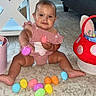 Remi joined the competition — help win amazing prizes! baby, child, easter_eggs, carpet, pink_basket, red_basket, bunny_ears, candy, snacks, floor, indoors, cute, holiday, festive, smiling, sitting, colorful, toy, person, diaper