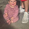 Remi joined the competition — help win amazing prizes! adult_legs, baby, barefoot, casual, child, concrete_floor, cute, footwear, happy, indoor, infant, person, pink_clothing, playful, portrait, shorts, sitting, smiling, white_sneakers, young_child
