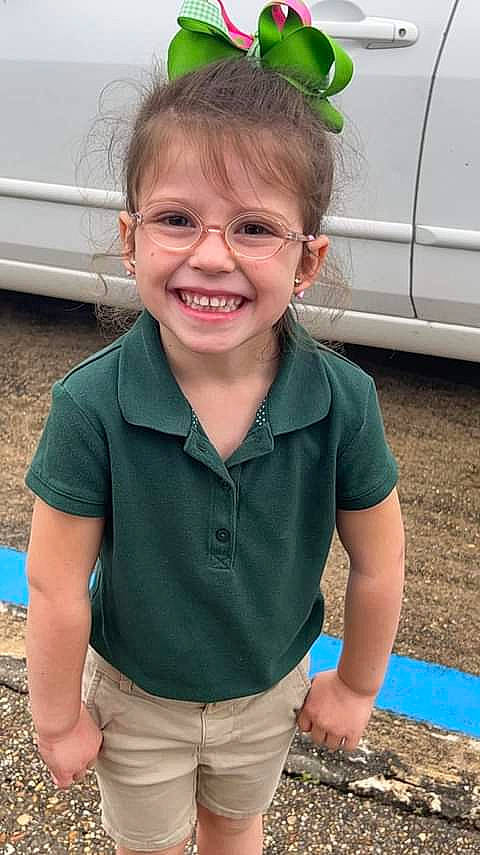 Kinlee is registered to the contest to win money with this photo: automotive_tire, child, chin, eye, face, facial_expression, fun, glasses, grass, green, hair, hairstyle, happy, joy, person, skin, sleeve, smile, summer, t_shirt