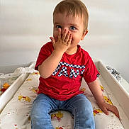 Tyméo participe au concours pour gagner de l'argent avec cette photo : baby, blue_eyes, casual, changing_table, child, clothing, cute, hand, indoor, jeans, person, playful, portrait, red_shirt, sitting, smiling, sock, toddler, winnie_the_pooh, young_child
