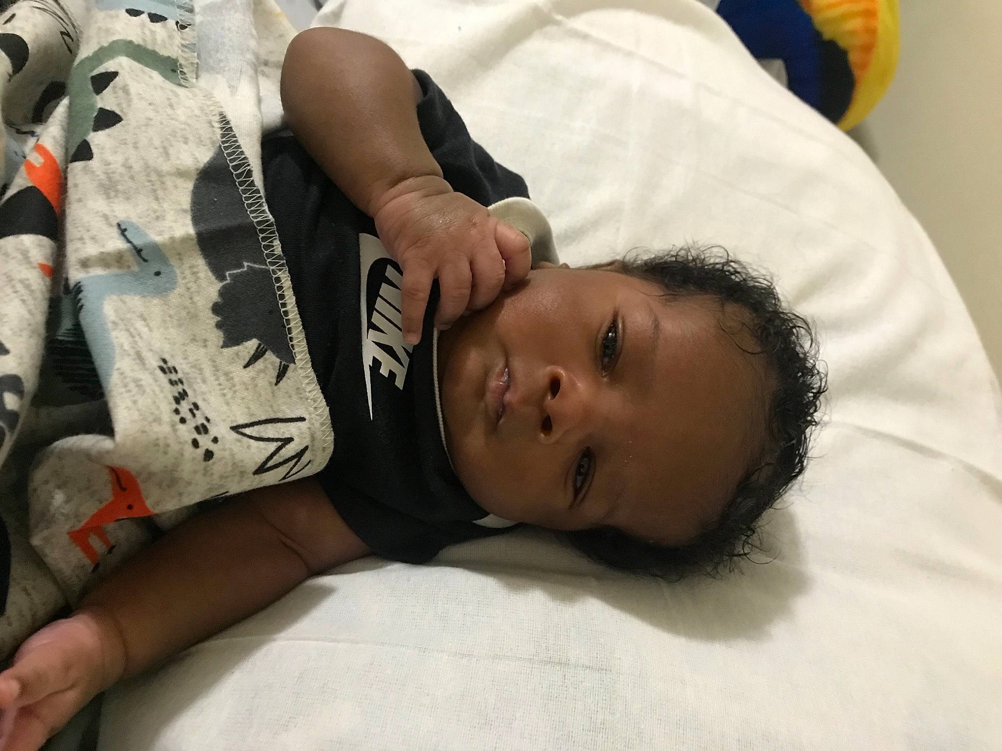 Dakarai is registered to the contest to win money with this photo: abdomen, black_hair, chest, child, comfort, elbow, eyelash, eyewear, hand, linens, nap, neck, person, room, skin, t_shirt, tattoo, thigh, toddler, tree