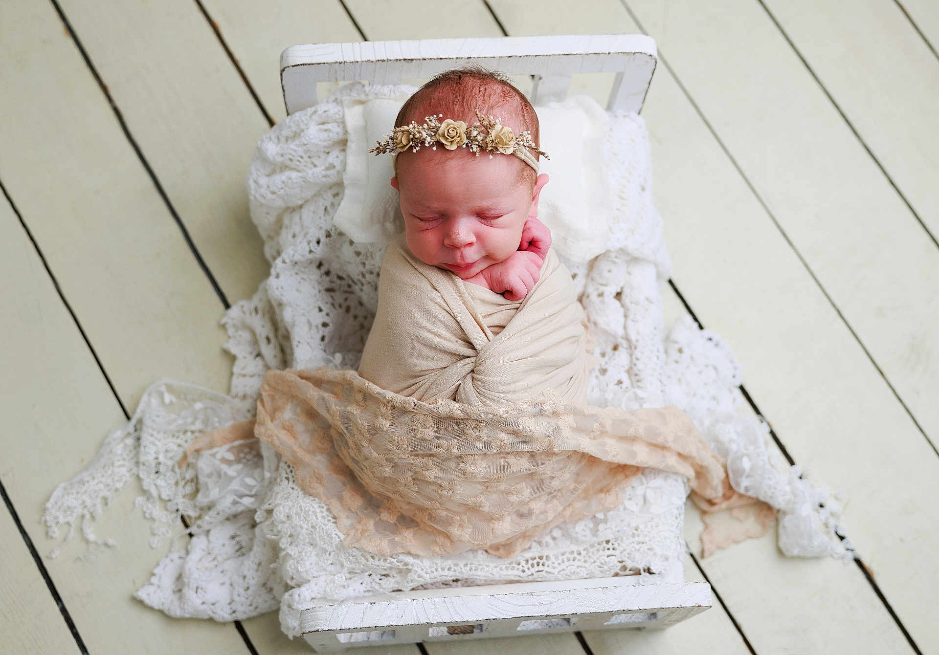 Eloisa is registered to the contest to win money with this photo: newborn, baby, swaddle, headband, flower_crown, sleeping, bed, white_bed, lace_blanket, wooden_floor, infant, cute, peaceful, portrait, resting, soft_texture, wrapped, small_bed, delicate, cozy