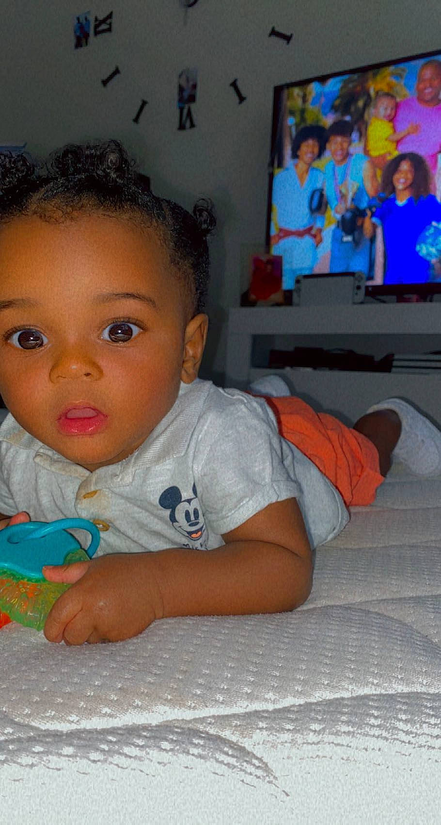 Alayann participe au concours pour gagner de l'argent avec cette photo : baby, baby_toddler_clothing, blurred, cheek, child, couch, face, flooring, fun, happy, human_leg, nose, person, room, sitting, skin, smile, t_shirt, television, television_set