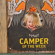 Emilia joined the competition — help win amazing prizes! child, toddler, blond_hair, smiling, face, portrait, halloween, spooky, ghosts, sign, wooden_sign, orange, pumpkin, outdoor, camping, camper, playful, happy, photograph, text