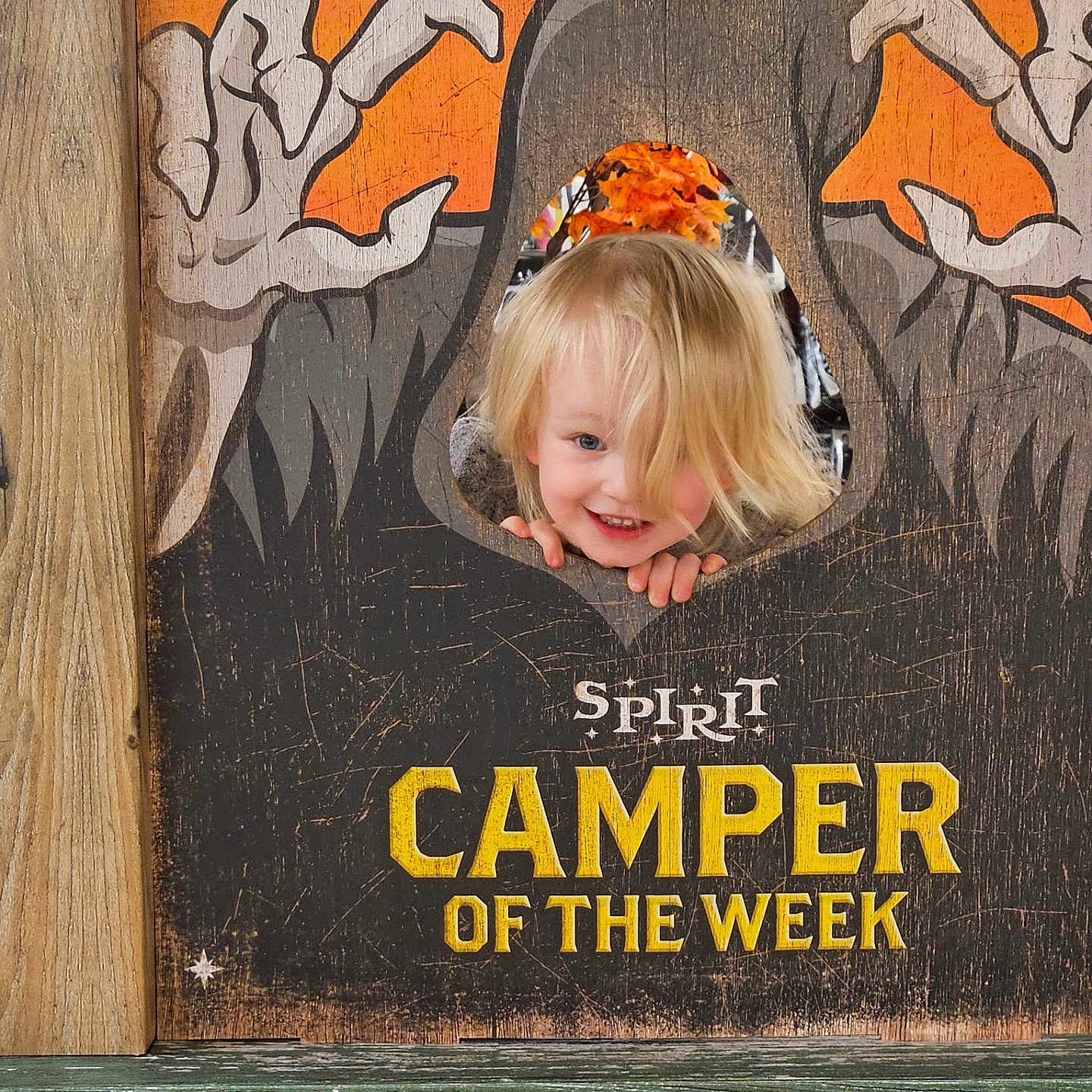 Emilia joined the competition — help win amazing prizes! child, toddler, blond_hair, smiling, face, portrait, halloween, spooky, ghosts, sign, wooden_sign, orange, pumpkin, outdoor, camping, camper, playful, happy, photograph, text