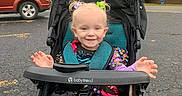 Emilia is registered to the contest to win money with this photo: autumn, babytrend_stroller, car, child, colorful_clothing, daytime, fall_foliage, hair_ties, happy, outdoor, parking_lot, pavement, person, pigtails, playful, smile, striped_leggings, stroller, toddler, tree