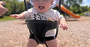 Ember is registered to the contest to win money with this photo: baby, blue_sky, child, clothing, daytime, fun, hand, happy, hat, outdoor, park, playground, recreation, shorts, slide, smiling, sunny, swing, trees, tshirt