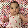 baby, infant, child, face, eyes, dress, strawberry_pattern, blanket, crochet, colorful, cute, skin, hand, foot, lying_down, indoors, portrait, expression, curious, young