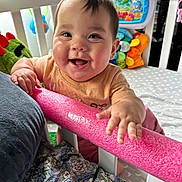 Ember joined the competition — help win amazing prizes! baby, child, crib, toy, smile, happy, indoor, infant, colorful, foam_bar, person, young_child, play, cute, furniture, clothing, face, hand, bed, expression