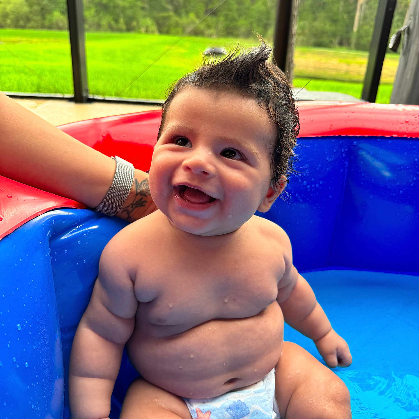 Kai is registered to the contest to win money with this photo: accessories, baby, bracelet, clothing, diaper, face, grass, happy, head, jewelry, outdoors, person, photography, plant, playarea, pool, portrait, summer, swimwear, water