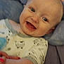 Jaxon is registered to the contest to win money with this photo: baby, smiling, infant, blanket, hand, clothing, cute, portrait, happy, child, face, skin, eyes, lying_down, cozy, indoors, person, young, toddler, expression
