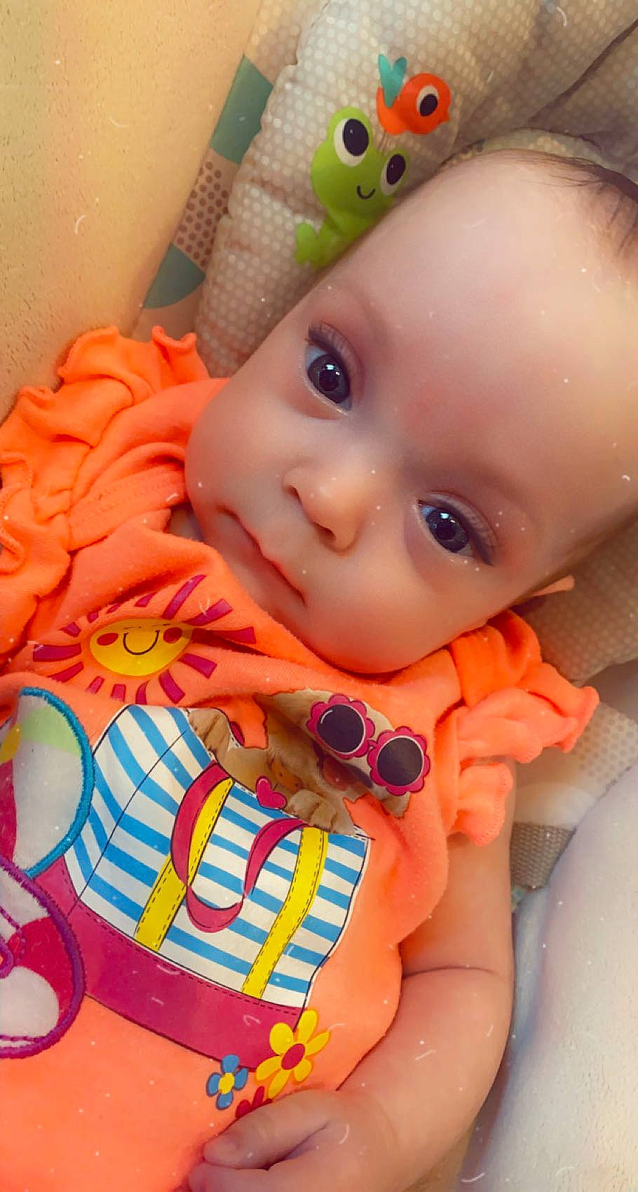 Xiamara is registered to the contest to win money with this photo: baby, baby_toddler_clothing, cheek, face, facial_expression, finger, happy, iris, lip, mouth, nose, orange, organ, person, pink, product, skin, sleeve, textile, white