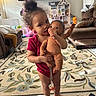 Harmonie joined the competition — help win amazing prizes! toddler, child, doll, living_room, carpet, sofa, toy, television, floor_lamp, curly_hair, pink_clothing, home_interior, cushion, blanket, person, furniture, play, indoor, cute, baby