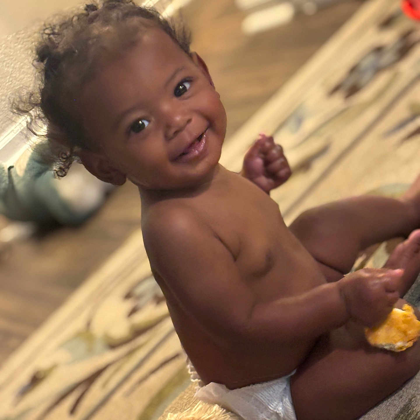 Devonie joined the competition — help win amazing prizes! baby, child, diaper, smile, indoor, carpet, snack, curly_hair, plush_toy, happy, toddler, person, cute, sitting, home, floor, infant, playful, bright_eyes, young