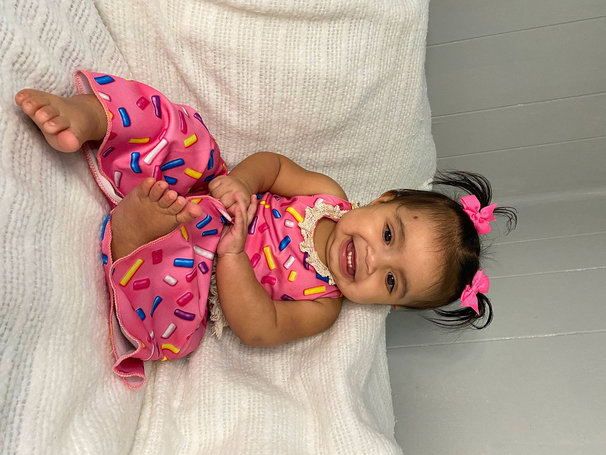 Noelani is registered to the contest to win money with this photo: abdomen, baby, baby_toddler_clothing, dress, eye, happy, head, headgear, human_body, joy, knee, leg, mouth, neck, person, pink, skin, smile, textile, thigh