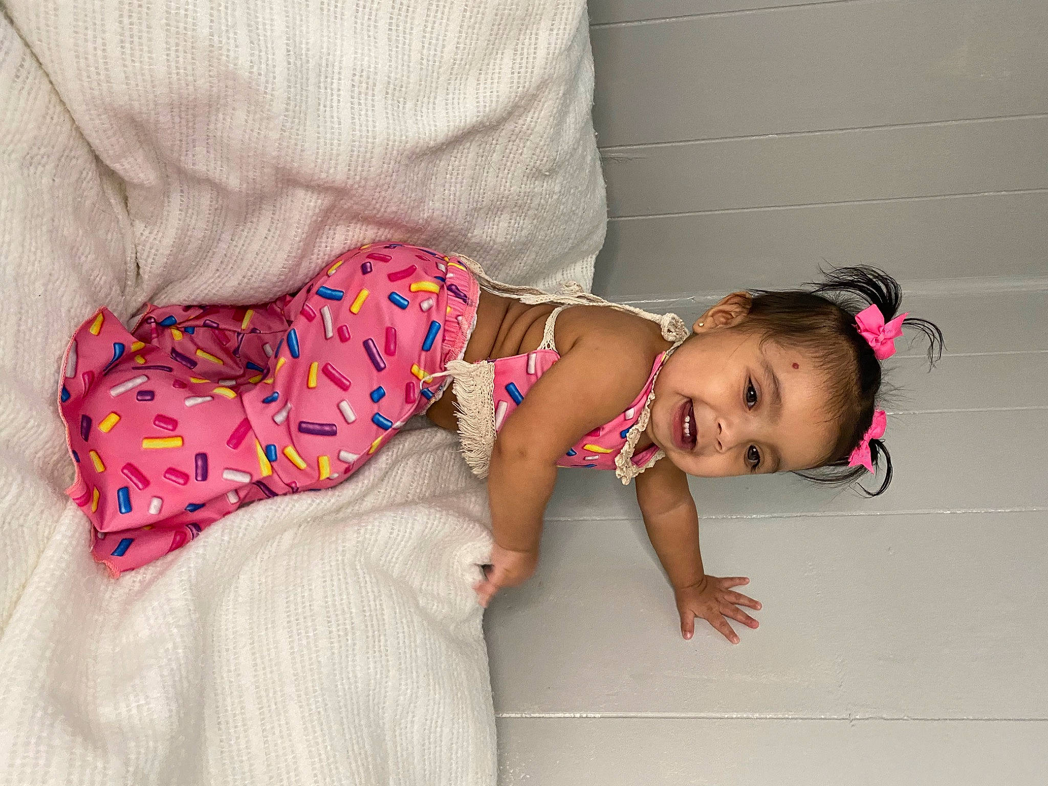 Noelani is registered to the contest to win money with this photo: baby, baby_products, baby_toddler_clothing, cheek, child, comfort, finger, flooring, foot, head, human_body, joy, leg, magenta, pattern, person, pink, skin, sleeve, sock