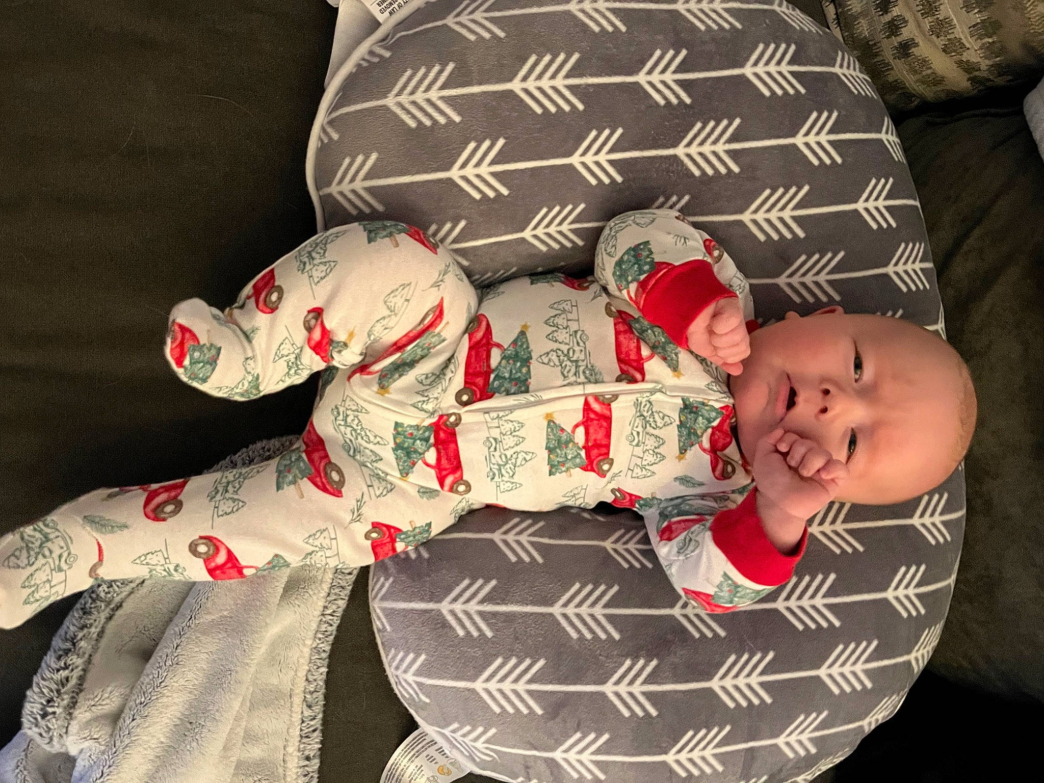 Knox is registered to the contest to win money with this photo: baby, baby_products, baby_sleeping, baby_toddler_clothing, carmine, child, comfort, creative_arts, fashion_accessory, head, headgear, human_body, lap, linens, pattern, person, room, sitting, sleeve, smile