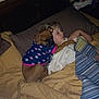bed, blanket, child, clothing, dog, dog_clothing, furniture, hair, head, indoor, night, pajamas, pet, pillow, sleeping, sleepwear, toddler, toy, warm, young