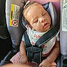 baby, infant, sleeping, car_seat, harness, safety_belt, vehicle, portrait, close_up, indoors, pink_clothing, bow, bib, seated, peaceful, sleepy, child, face, hands, photography