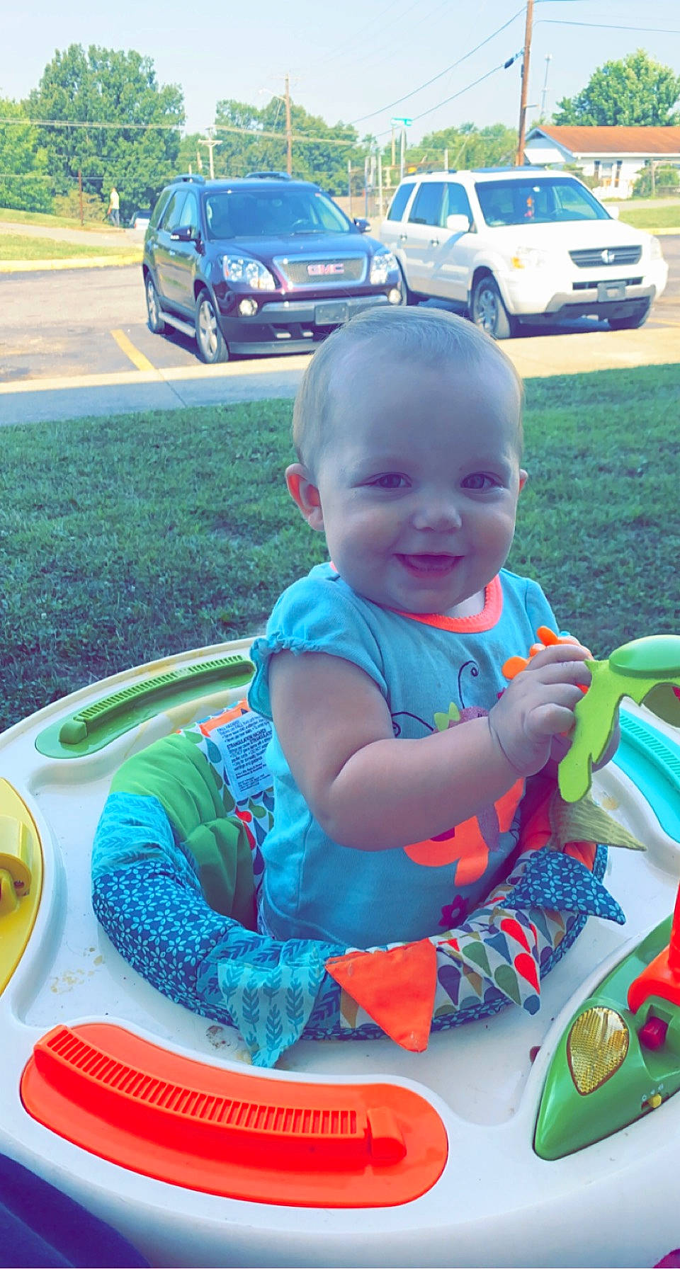 Kylee is registered to the contest to win money with this photo: automotive_exterior, baby, baby_toddler_clothing, blue, car, grass, green, happy, joy, land_vehicle, leisure, motor_vehicle, person, plant, recreation, smile, tire, toddler, toy, vehicle