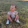 toddler, child, grass, outdoor, field, shoes, bow, hair, floral_clothing, curious_expression, sunlight, nature, young_child, casual, cute, small_hair_tie, squatting, daytime, person, bare_legs