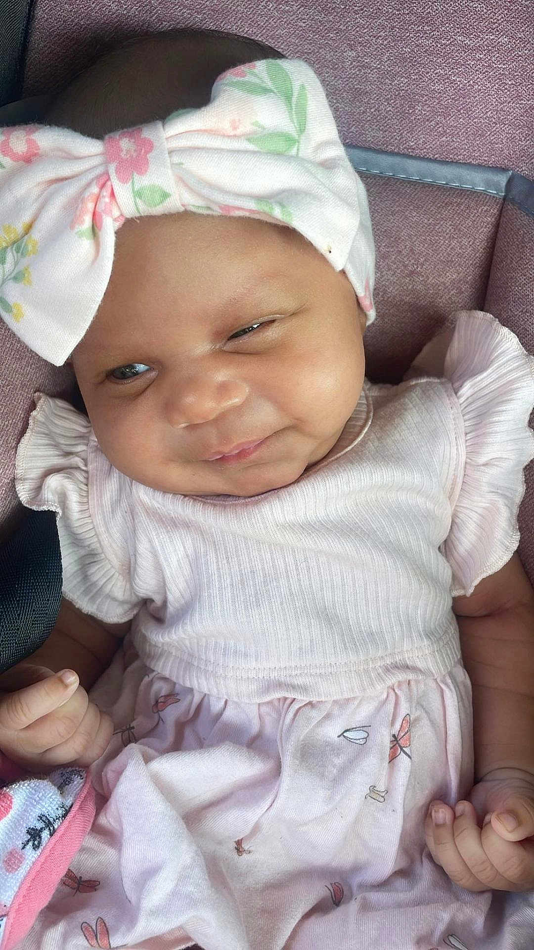 Royalti joined the competition — help win amazing prizes! baby, infant, child, headband, bow, dress, pink, smile, face, hand, cushion, fabric, blanket, seated, cute, skin, eyes, clothing, indoor, portrait