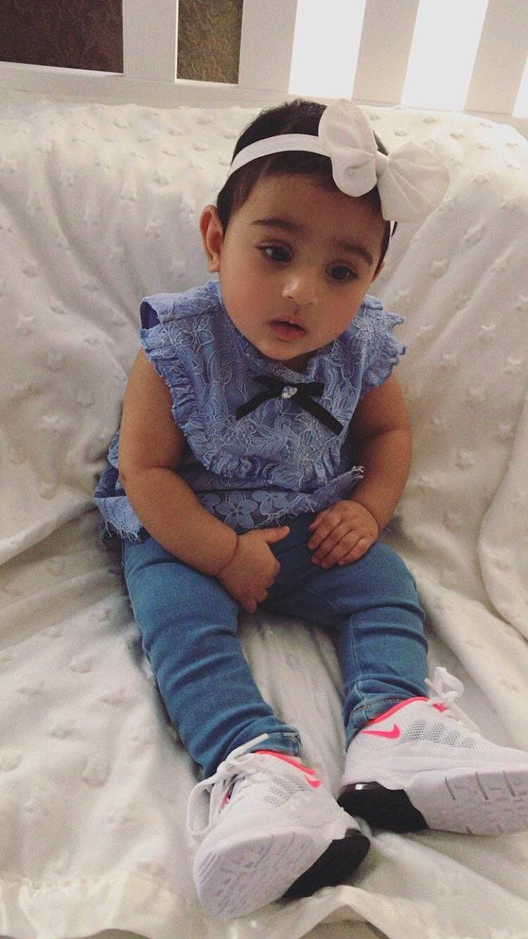 Aisha is registered to the contest to win money with this photo: arm, baby, cheek, child, finger, hair_accessory, headgear, person, sitting, skin, toddler