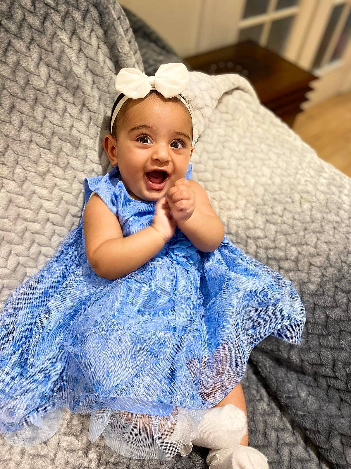 Aisha joined the competition — help win amazing prizes! baby, beauty, blue, child, costume, dress, eye, facial_expression, hair_accessory, happy, headgear, person, sitting, skin, smile, textile, toddler