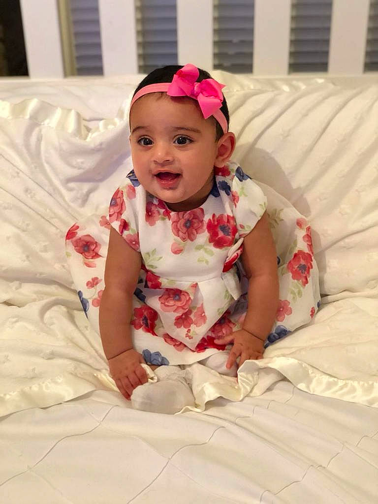 Aisha is registered to the contest to win money with this photo: baby, child, hair_accessory, headband, headgear, person, pink, smile, textile, toddler