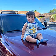 Ethan is registered to the contest to win money with this photo: blue_sky, car, casual_clothing, child, daytime, face, hair, hood, outdoor, person, pikachu, reflection, shorts, smiling, socks, suburban, sunlight, tank_top, toddler, vehicle