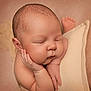 baby, blanket, chubby_cheeks, closeup, cozy, ear, fingers, foot, hand_on_cheek, head, infant, newborn, peaceful, pillow, portrait, skin_texture, sleeping, soft_lighting, studio_photography, warm_tones