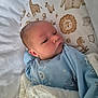 baby, infant, blanket, blue_onesie, crib, animal_print, giraffe, lion, sleepwear, cute, newborn, face, child, bed, soft, pattern, cozy, resting, indoors, peaceful