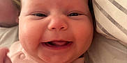 Gracie joined the competition — help win amazing prizes! baby, smiling, face, infant, cheeks, clothing, pink, pillow, blanket, bed, person, happy, cute, skin, head, closeup, portrait, indoors, newborn, child
