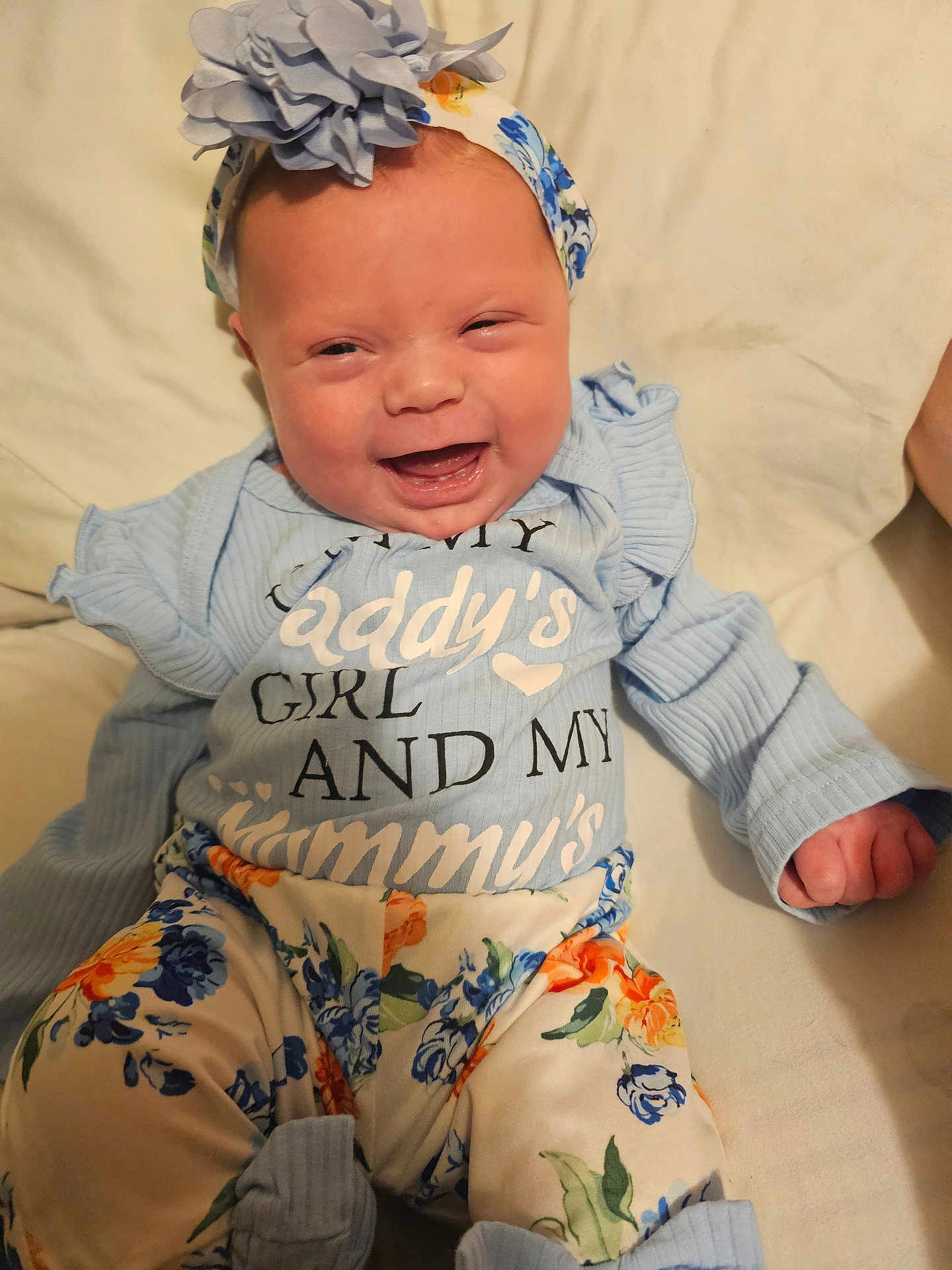 Tia Lee-Ann Gann is registered to the contest to win money with this photo: baby, smiling, infant, headband, flower, blue_clothing, floral_pattern, cute, happy, sitting, child, portrait, indoor, soft_light, young, person, apparel, baby_girl, closeup, cheerful
