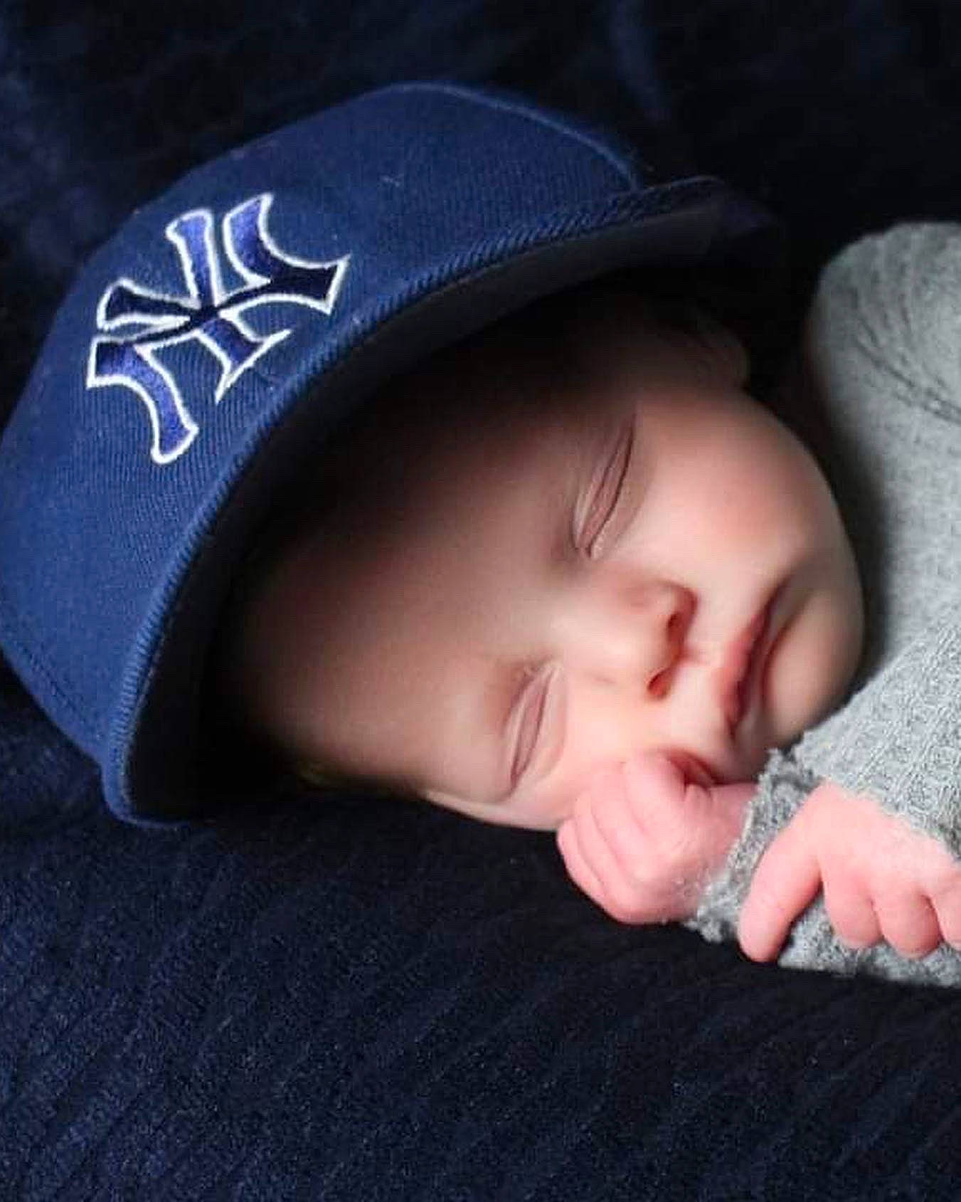 Enzo is registered to the contest to win money with this photo: baby, baby_toddler_clothing, baseball_cap, cap, cheek, child, comfort, cool, electric_blue, eyelash, fashion_accessory, flash_photography, gesture, hand, happy, headgear, headwear, lip, material_property, pattern