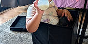 Aria is registered to the contest to win money with this photo: bed, blanket, box, carpet, child, cozy, curly_hair, curtain, floor, furniture, happy, indoor, milk_bottle, person, pillow, room, sitting, smiling, toddler, window