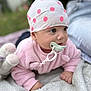 baby, blanket, child, close_up, cozy, cute, expression, gaze, hat, headwear, infant, lying_down, outdoor, pacifier, person, pink_clothing, plush_toy, polka_dots, soft_texture, young