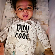 Zack participe au concours pour gagner de l'argent avec cette photo : baby, infant, onesie, animal_print, smiling, tongue_out, blanket, cute, child, cozy, lying_down, hand, plush_toy, curly_hair, face, happy, indoors, soft_lighting, patterned_fabric, young_child