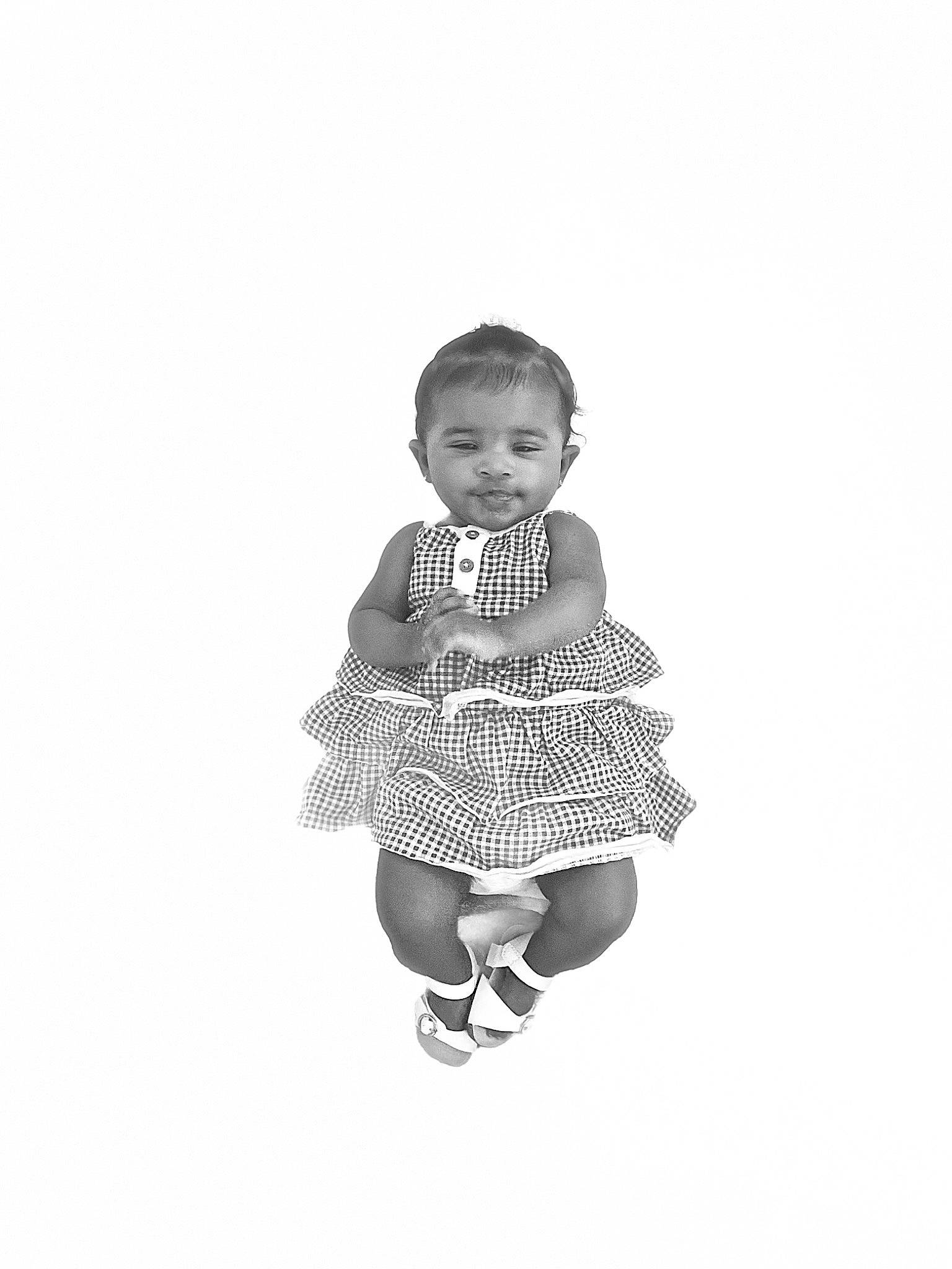 Karli is registered to the contest to win money with this photo: baby, baby_toddler_clothing, child, face, fashion_accessory, fashion_design, gesture, happy, human_leg, knee, leg, monochrome, monochrome_photography, pattern, person, sitting, sleeve, smile, t_shirt, toddler